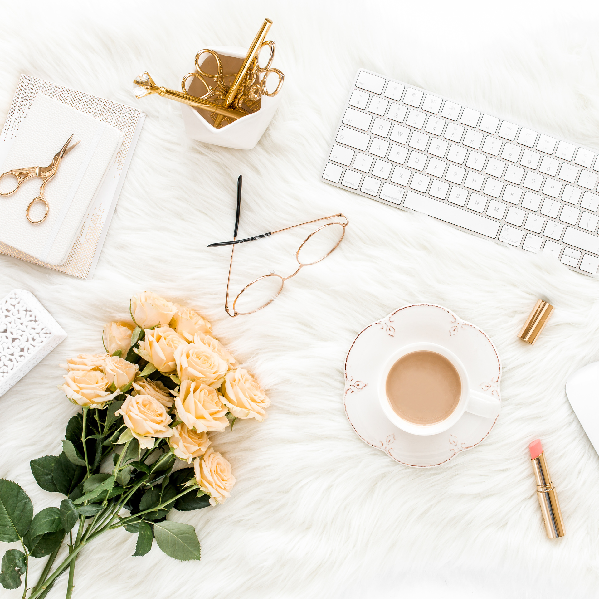 Female workspace with laptop, roses flowers bouquet, golden accessories, diary, computer, glasses on white background. Flat lay women's office desk. Top view feminine background.